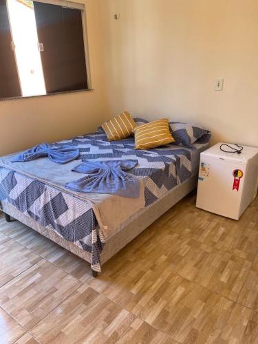 a bedroom with a bed and a small refrigerator at Pousada Fonseca in Salinópolis