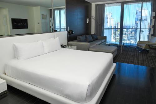 a bedroom with a large white bed and a living room at Palms Place Hotel and Spa in Las Vegas