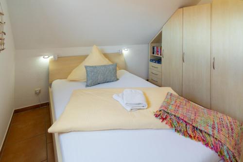 a small bedroom with a bed with a towel on it at Exklusive Ferienwohnung Sonnenplatz 30 in Norddeich