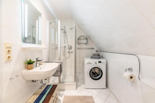 a white bathroom with a sink and a washing machine at Wrixum - Herrenhof Nr 7 Leevhüs in Wrixum
