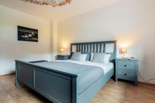 a bedroom with a large bed and two night stands at Waldnest Braunlage in Braunlage