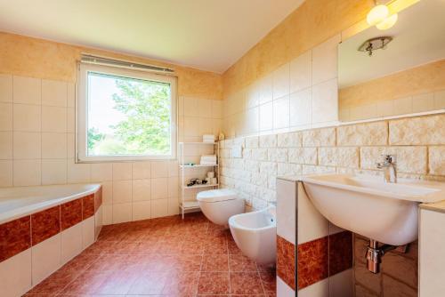 a bathroom with two sinks and a tub and a toilet at Waldnest Braunlage in Braunlage
