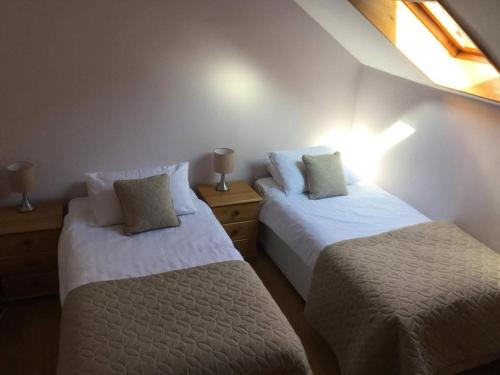 a bedroom with two beds and a window at Heaven Above the Haven in Millport