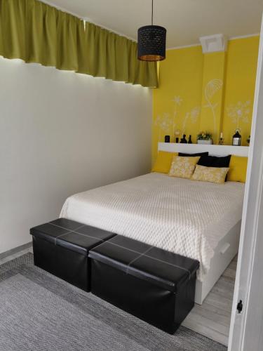 a bedroom with a bed with a black ottoman at Duna Kuckó in Mohács
