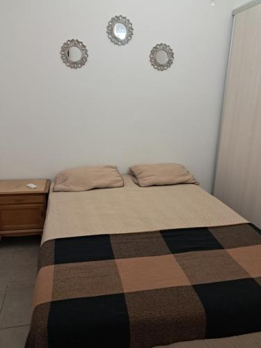 a bed in a bedroom with two clocks on the wall at Residencial 43 in La Plata