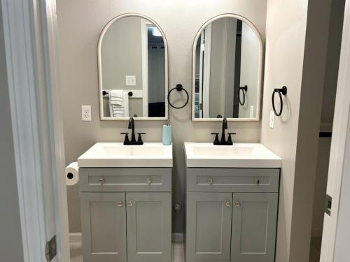 a bathroom with two sinks and two mirrors at Woodrow St in Arlington