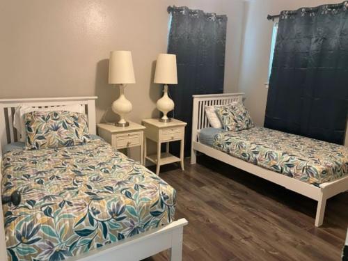 a bedroom with two beds and two lamps on tables at Woodrow St in Arlington