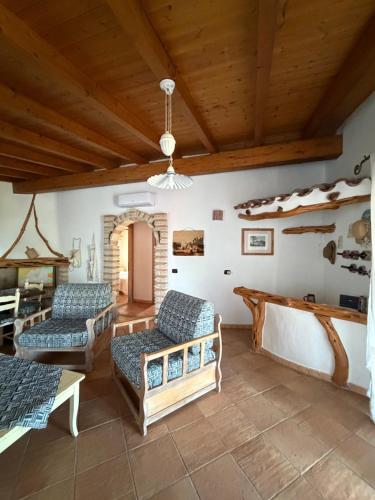 a living room with couches and a wooden ceiling at Villa Veronica in Sedini