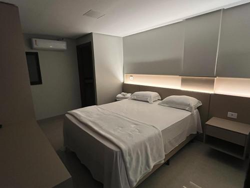a bedroom with a large white bed in a room at Mega Palace Hotel in Morrinhos