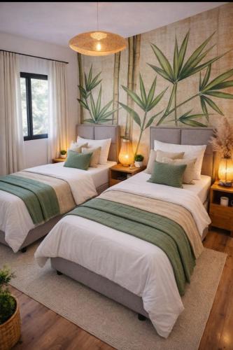 a bedroom with two beds and a large plant on the wall at Hoota Cottage Bojana River in Ulcinj