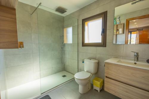 a bathroom with a toilet and a shower and a sink at Casa L'Escala 31 in L'Escala