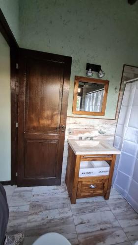 a bathroom with a sink and a wooden door at Cabañas Altos de San Blas 3 in Pueblito