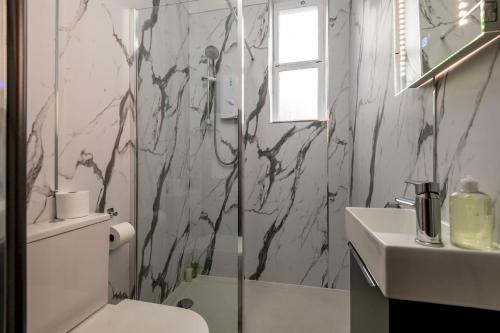 a bathroom with a shower and a toilet and a sink at Church View - Elie in Elie