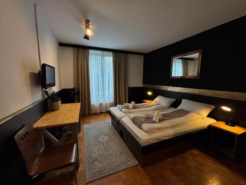 a hotel room with two beds and a television at Guest House Park Žibert in Ljubljana
