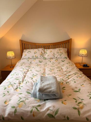 a bed with a towel on it with two lamps at Little Lemon in Reydon