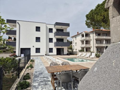 an outdoor patio with a table and chairs next to a building at Apartments Natalija1 -Krk in Krk