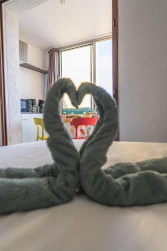 a pair of snakes forming a heart on a bed at Escapade Marine - Vue Etang - Place de parking privé - Plage à 5 min in Le Barcarès