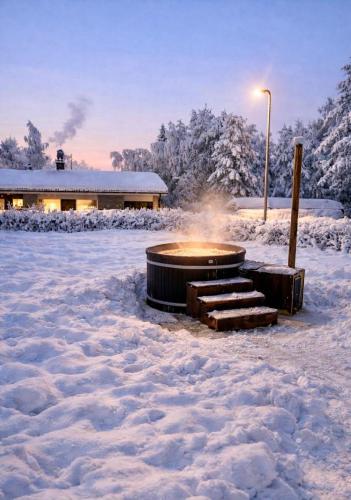 a fire pit in the snow with a building in the background at Willa Reindeer - komfortowy dom w sercu Laponii! in Pello