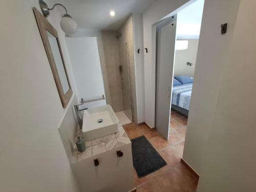 a bathroom with a sink and a mirror and a bed at Finca Mirador in Macastre
