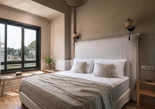 a bedroom with a large bed and a large window at Dia Viou Rene in Paradisos