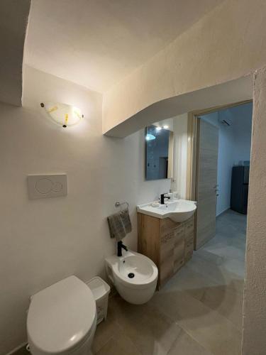 a bathroom with a white toilet and a sink at Le Pozzelle Presicce, Bilocale Casa a Corte XVI sec in Presicce