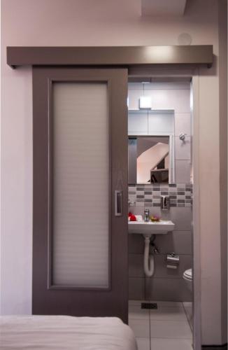 a door leading into a bathroom with a sink at Sobe i Apartmani Vila Modex in Paraćin