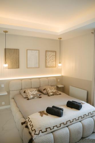 a bedroom with a bed with two pillows on it at Suite Maiora - Élégance, Sérénité & Jacuzzi in Saumur