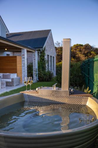 a large pool of water in a yard with a house at Modern Coastal Retreat - Private Hot Tub & Sauna in Hermanus