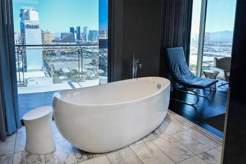 a white bath tub in a room with a large window at Palms Place Hotel and Spa in Las Vegas