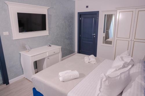 a bedroom with a bed and a sink and a tv at Pensiunea Paradisul Mării in Sulina