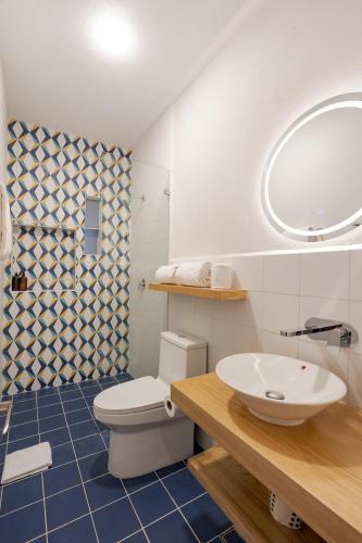 a bathroom with a white toilet and a sink at Guadalupe Inn in Mexico City