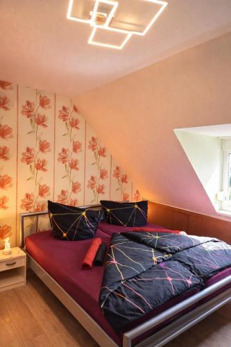 a bedroom with a bed with purple sheets and flowers on the wall at Holiday Rhein 5 in Boppard