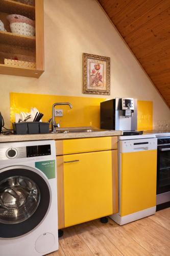 a yellow kitchen with a washing machine in it at Holiday Rhein 5 in Boppard