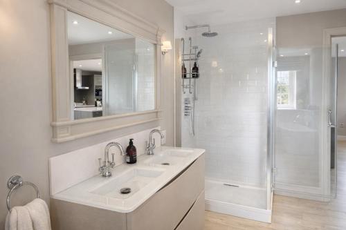 a white bathroom with two sinks and a shower at Yarwell Mill in Nassington