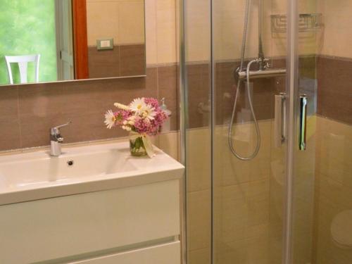 a bathroom with a sink and a shower with a vase of flowers at B&B - TallyHo in Salve