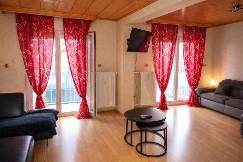a living room with red curtains and a table at Holiday Rhein 4 in Boppard