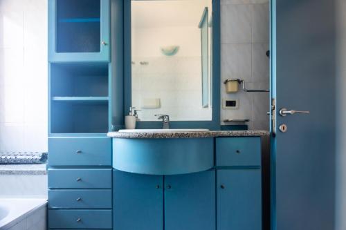 a blue bathroom with a sink and a mirror at Casa la Gabbianella in San Teodoro