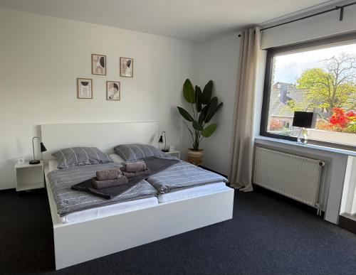 a white bedroom with a bed and a window at Renovierte Doppelhaushälfte in bester Lage in Bottrop
