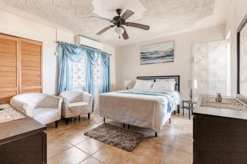 a bedroom with a bed and a ceiling fan at Oceanview Retreat in Bull Bay