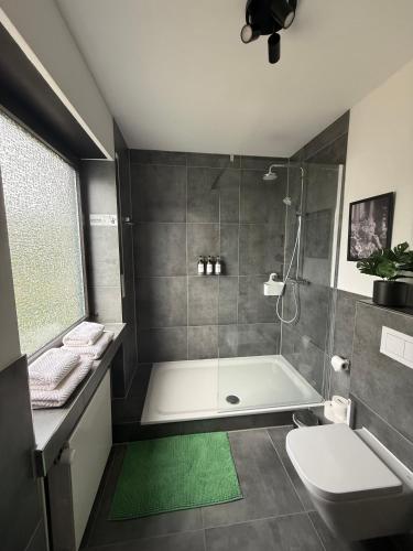a bathroom with a shower and a tub and a toilet at Renovierte Doppelhaushälfte in bester Lage in Bottrop