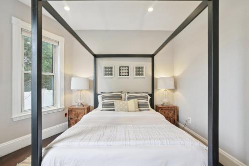 a bedroom with a black and white bed with two lamps at Boston Escape Near T in Boston