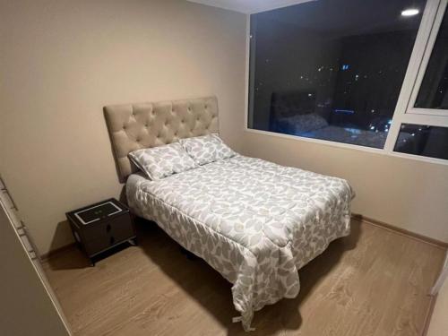 a small bedroom with a bed and a window at Laurel de oro in Chillán