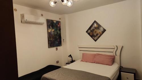 a bedroom with a bed and a painting on the wall at Maison Verde Madinaty in Cairo
