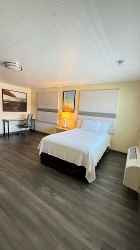 a bedroom with a large bed with a white bedspread at Citrus Inn & Suites in Porterville