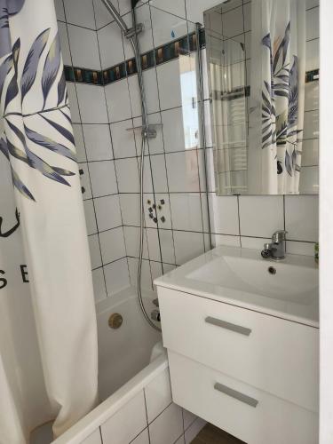 a white bathroom with a sink and a mirror at Appartement station Piau-Engaly in Aragnouet