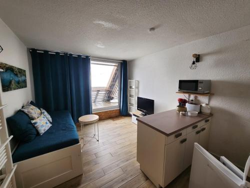 a small room with a bed and a desk with a window at Appartement station Piau-Engaly in Aragnouet