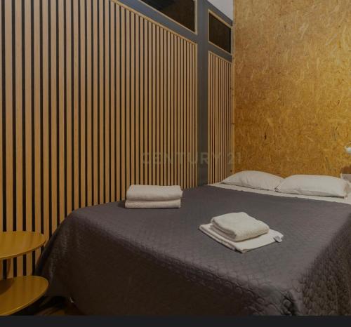 a bedroom with a bed with two towels on it at Portela Room in Carnaxide