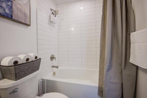 a bathroom with a white tub and a toilet at Open concept with city views in Kitchener