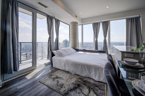 a bedroom with a bed and large windows at Open concept with city views in Kitchener