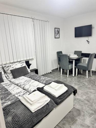 a bedroom with a bed and a table with chairs at Vila Cirkovic - 200m od mermernog setalista in Soko Banja